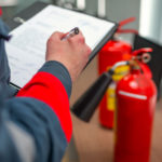 Engineer,Professional,Are,Checking,A,Fire,Extinguisher,Using,Clipboard,Or