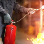 Man,Using,Fire,Extinguisher,Fighting,Fire,Closeup,Photo